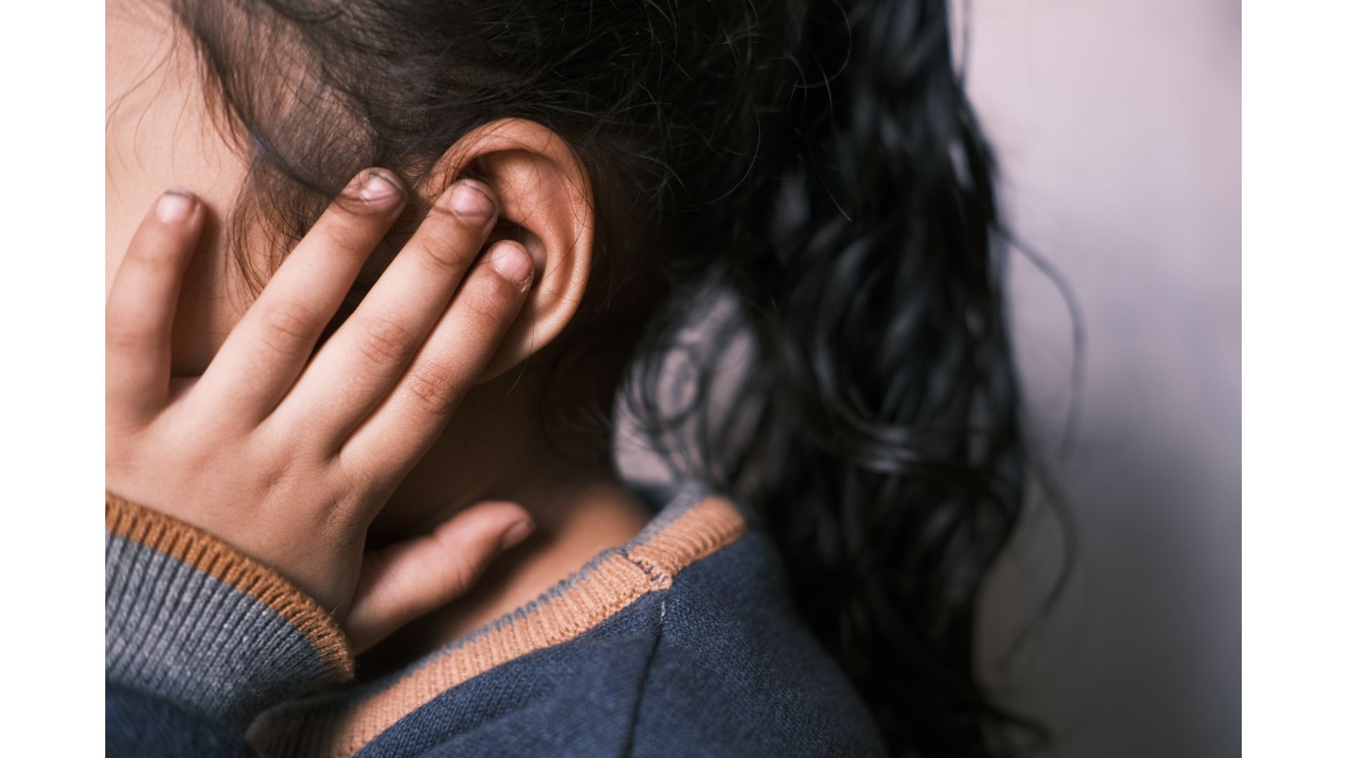 kid holding ear